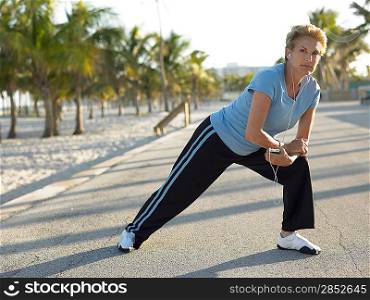Senior woman stretching on tropical beach