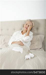 Senior woman suffering from headache resting in bed