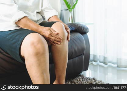 senior woman suffering from knee pain at home, health problem concept