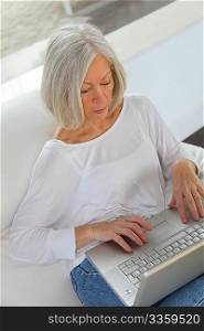 Senior woman surfing on internet at home