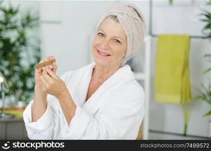 senior woman takes care of her manicure