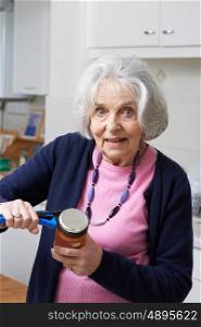 Senior Woman Taking Lid Off Jar With Kitchen Aid