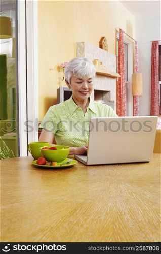 Senior woman using a laptop and smiling