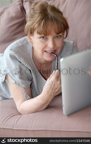 Senior woman using electronic tablet at home