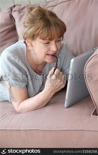 Senior woman using electronic tablet at home