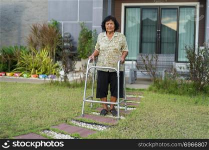 senior woman walking with walker at home