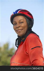 Senior woman wearing cycling helmet, outdoors, portrait