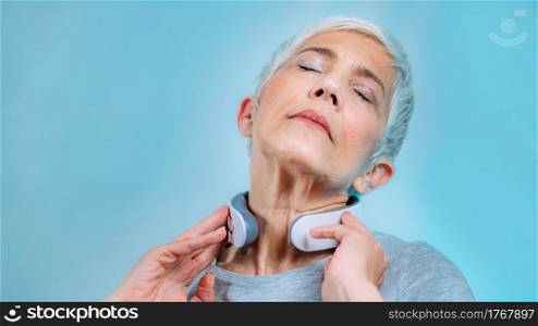 Senior woman wearing pulse neck massager. Pulse Neck Massager