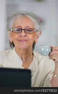 Senior woman with a coffee and a laptop