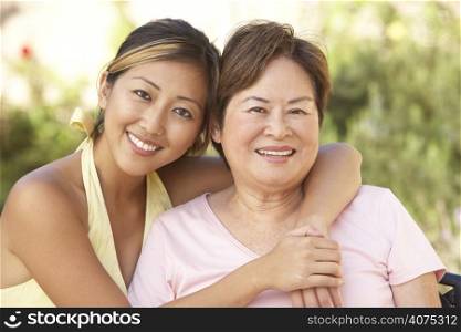 Senior Woman With Adult Daughter In Garden Together