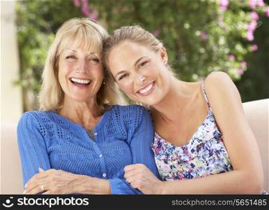Senior Woman With Adult Daughter Relaxing On Sofa At Home