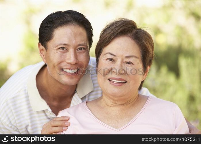 Senior Woman With Adult Son In Garden