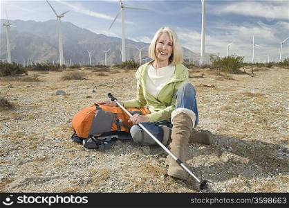 Senior woman with backpack near wind farm