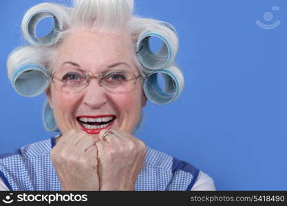 senior woman with curlers in her hair laughing