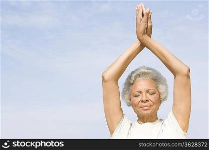 Senior woman with eyes closed in yoga pose
