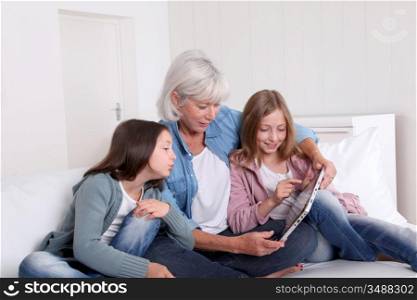 Senior woman with grandkids playing with touchpad