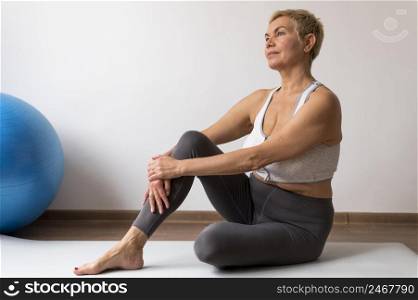 senior woman with short hair doing stretching exercises 2