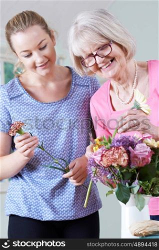 Senior Woman With Teacher In Flower Arranging Class