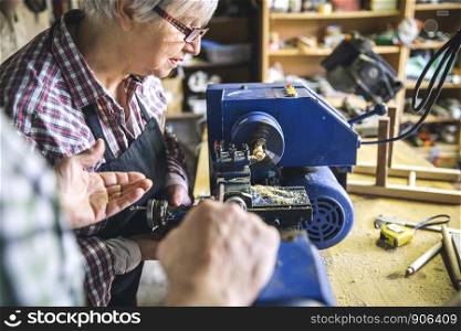 Senior woman working in a carpentry workshop. Senior woman in a carpentry