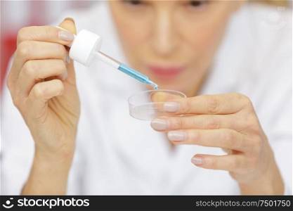 senior woman working with pipettes in a lab