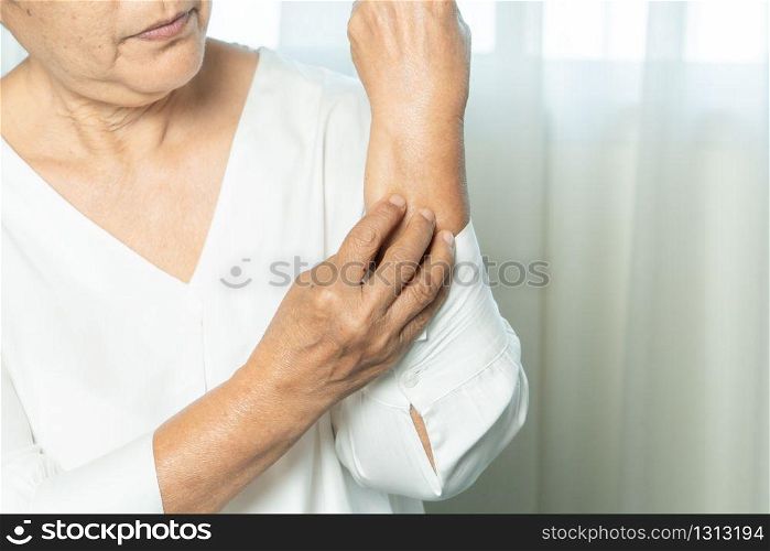 senior women scratch hand the itch on eczema arm, healthcare and medicine concept