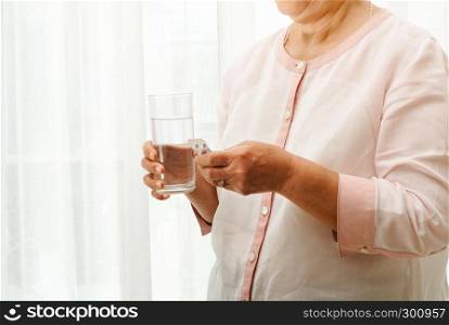 senior women take medicine with a glass of water, healthcare and medicine recovery concept