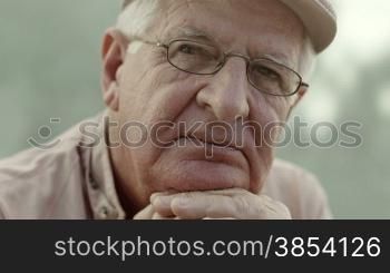 Seniors portrait of sad elderly man with white hat and glasses