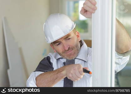 seniro man fitting a pvc window