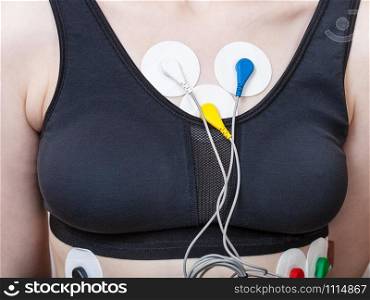 sensors of Holter monitor for electrocardiogram are attached to woman&rsquo;s torso