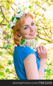 Sensual beautiful blond girl in a cherry flowers
