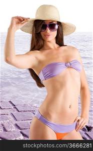 sensual beautiful brunette with long hair wearing a bikini swimsuit hat and sunglasses