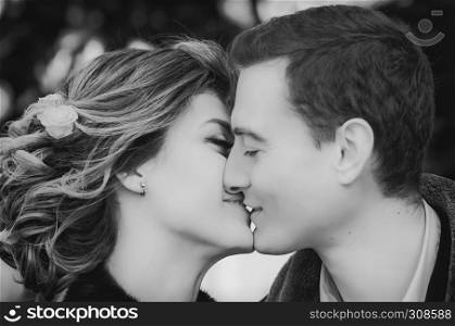 Sensual black and white portrait of happy kissing couple closeup - loving, newlyweds. Selective focus.. Monochrome Portrait Of Kissing Couple