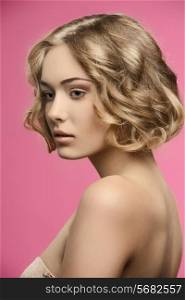 sensual blonde girl posing in beauty shoot with healthy short curly hair, natural make-up and naked shoulders