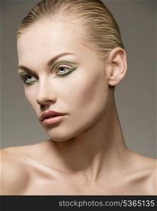 sensual blonde woman posing in beauty close-up portrait with naked shoulders, perfect skin and cute green make-up