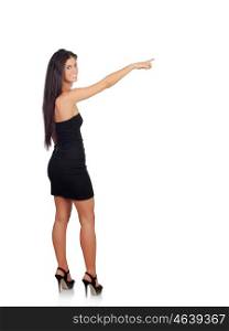 Sensual brunette girl with black dress indicating something isolated on a white background