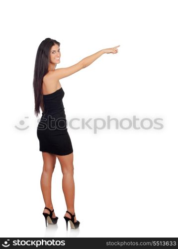 Sensual brunette girl with black dress indicating something isolated on a white background