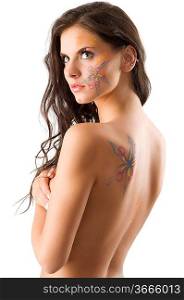 sensual brunette with a flower tattoo on her face and on her naked back