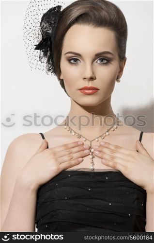 sensual brunette woman in close-up shoot posing with black evening dress and elegant hair-style