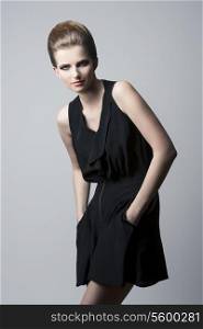 sensual brunette woman with elegant hair-style and make-up, black dress in fashion pose