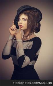 sensual fashion woman in charming pose with lovely black hat, striped dress and elegant necklace.