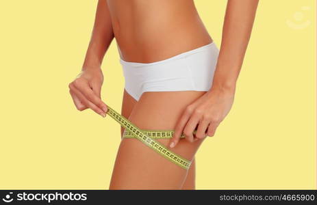 Sensual female body with bikini and tape measure isolated on a white background