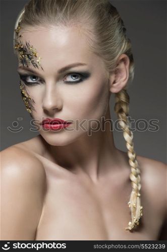 sensual girl posing in close-up shoot with naked shoulders, blonde bride hair-style and strong dark creative make-up on her visage