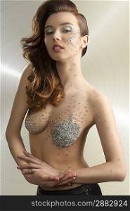 sensual girl with artistic make-up and fashion hair-style. Some glitter piece of mirror on her face and naked body