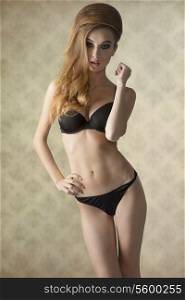 sensual girl with charming make-up and hair-style wearing black lingerie in fashion pose