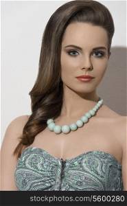 sensual girl with summer fashion style posing with elegant smooth hair-style, cute make-up and green necklace