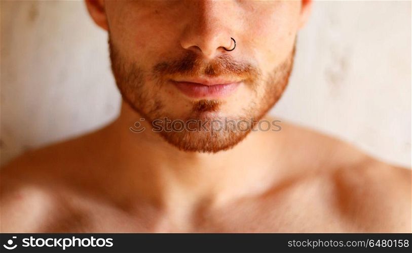 Sensual guy with a beautiful skin and a piercing on his nose