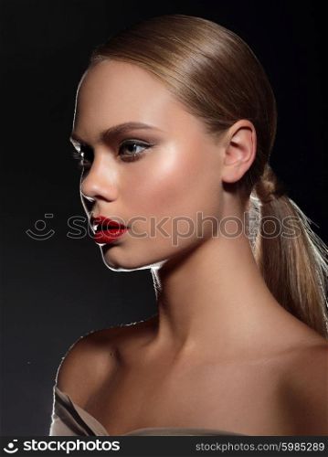 Sensual portrait of a beautiful glamor model woman with red lips with a clean healthy skin. Dark background.