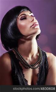 Sensual portrait of a beautiful woman with closed eyes over purple background, gorgeous lady with perfect hairstyle and makeup wearing black pearls beads, fashion look