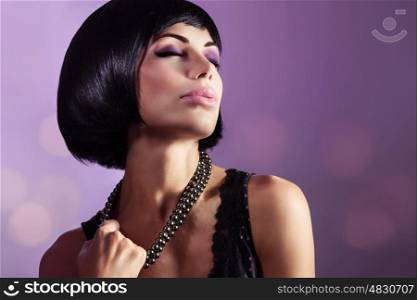 Sensual portrait of a beautiful woman with closed eyes over purple background, gorgeous lady with perfect hairstyle and makeup breaking her beads, fashion look