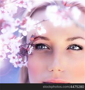 Sensual portrait of a spring woman, beautiful face, close up on blue eyes, female enjoying cherry blossom, dreamy girl with pink fresh flowers outdoor, seasonal nature, tree branch and natural beauty